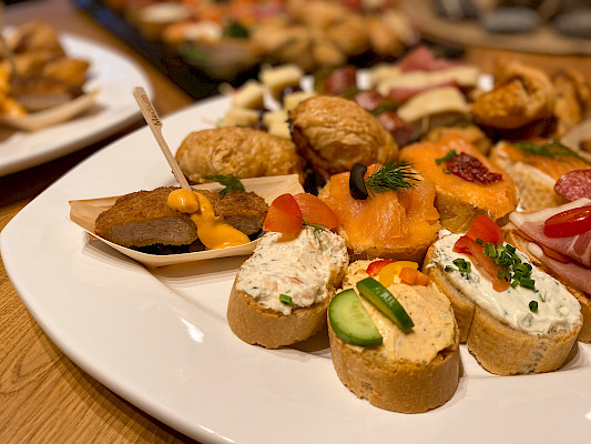 Fingerfood auf einem weißen Teller präsentiert.