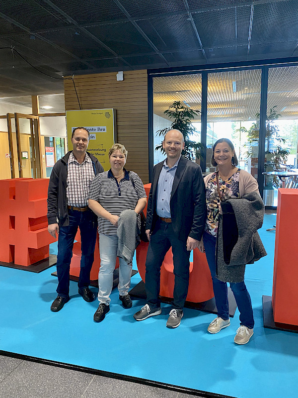 Andreas Fichtel, Bettina Fichtel, Frank Mayer und Ellen Mayer stehen vor einem Schild der Schüddeutschen Fleischermesse und lächeln in die Kamera.