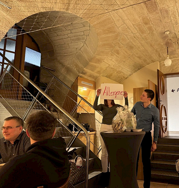 Verena Mayer hebt ein Schild in die Höhe und das Team der Metzgerei Mayer schaut in diese Richtung.